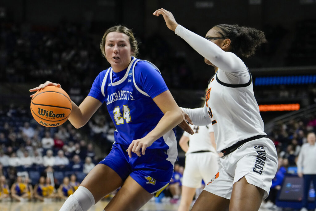 South Dakota State's Mesa Byom dribbles past Oklahoma State's Stailee Heard during their 2025 March Madness first-round game.