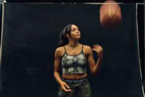 Jordan Brand athlete and wnba star napheesa collier poses with a basketball against a black backdrop.
