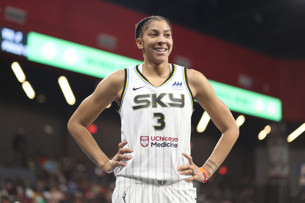 Chicago Sky star Candace Parker smiles and looks on during a 2022 WNBA game.