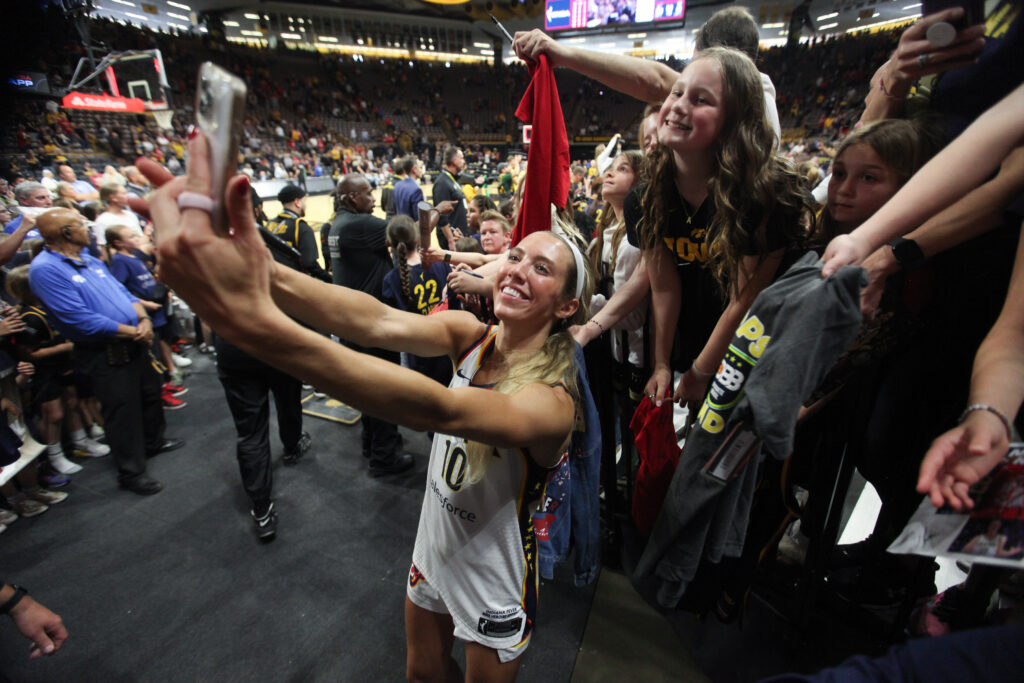 Indiana Fever guard Lexie Hull takes a selfie with a fan after a 2025 WNBA preseason game.