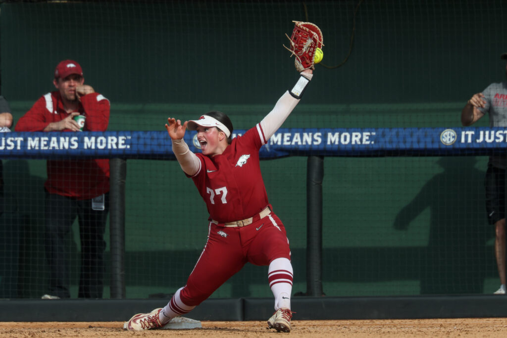 Arkansas softball's first baseman Bri Ellis triumphantly shows the ball after a close play during a 2025 SEC tournament game.