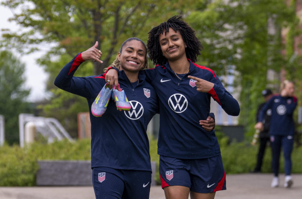 Catarina Macario and Lily Yohannes smile and pose as they walk into a USWNT training session.