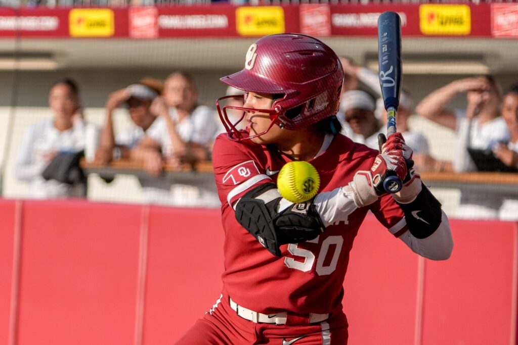 Oklahoma's Ailana Agbayani is grazed by a pitch during a 2025 NCAA softball game.