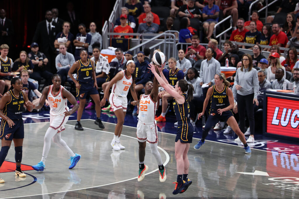 Connecticut Sun guard Saniya Rivers guards a three-point shot from Indiana Fever guard Caitlin Clark during a 2025 WNBA Commissioner's Cup game.