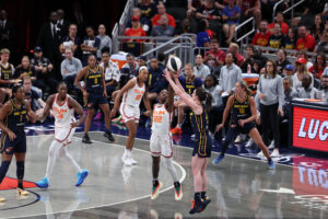 Connecticut Sun guard Saniya Rivers guards a three-point shot from Indiana Fever guard Caitlin Clark during a 2025 WNBA Commissioner's Cup game.