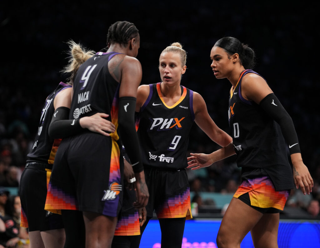 Phoenix Mercury players including Satou Sabally huddle during a 2025 WNBA game against the New York Liberty.