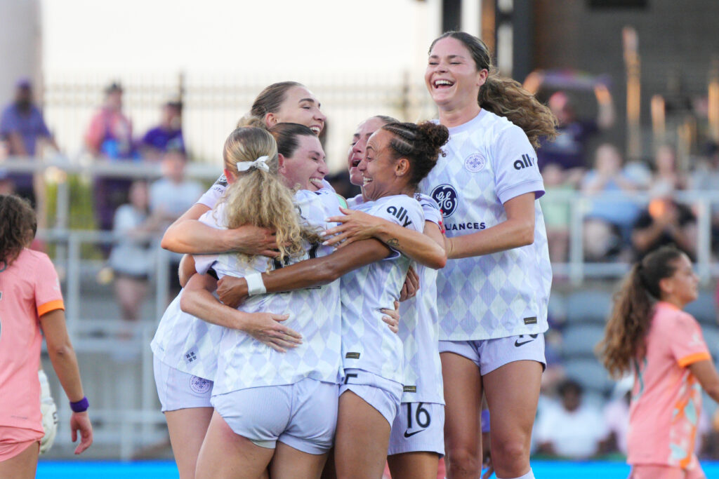 Racing Louisville teammates celebrate a goal by Arin Wright during a 2025 NWSL match.