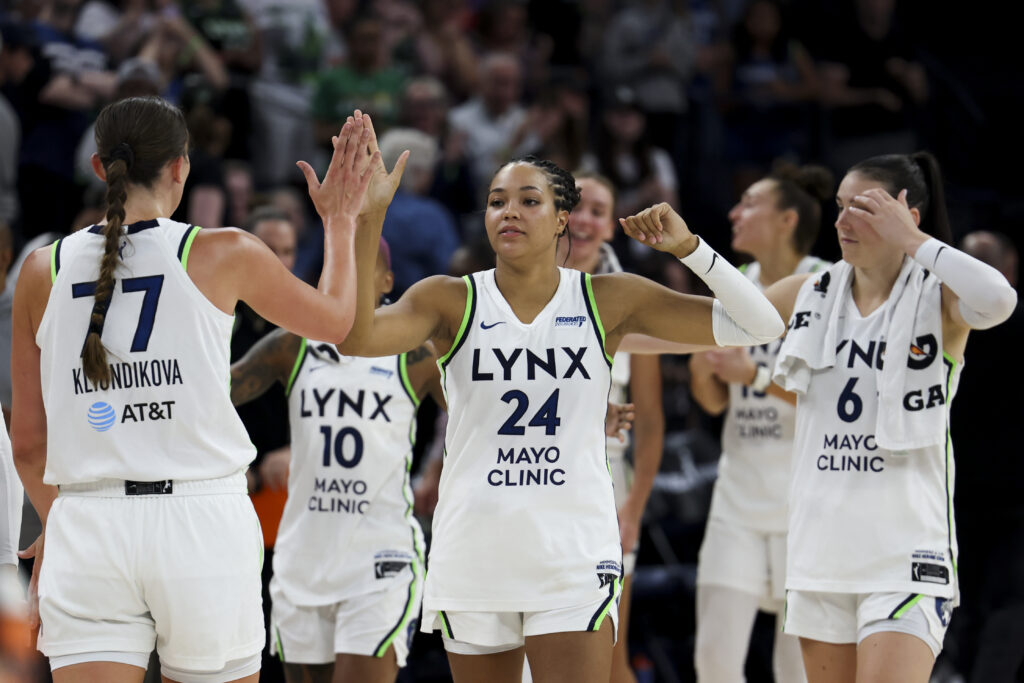 Naphees Collier high-fives her Minnesota Lynx teammates after a 2025 WNBA win.