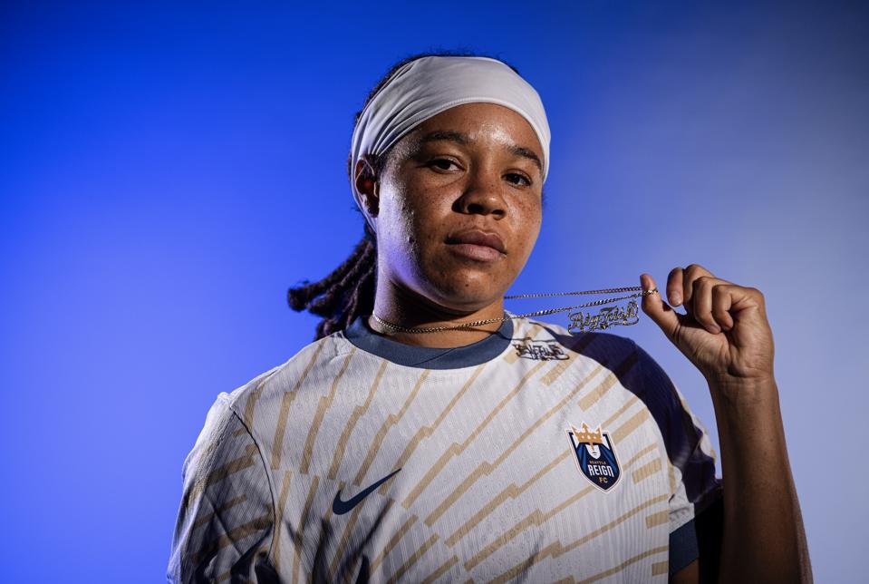 Forward Mia Fishel poses in a Seattle Reign jersey after signing with the NWSL club.