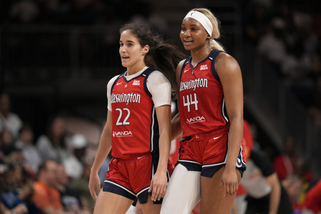 Washington Mystics rookie All-Stars Sonia Citron and Kiki Iriafen chat during a 2025 WNBA game.