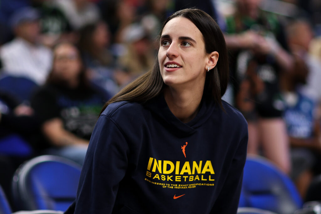 Injured Indiana Fever star Caitlin Clark looks on from the bench at the 2025 WNBA Commissioner's Cup championship game.