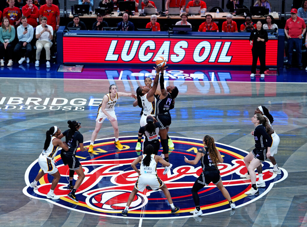 Indiana Fever center Aliyah Boston and Golden State Valkyries center Temi Fagbenle jump for the ball to start a 2025 WNBA game.