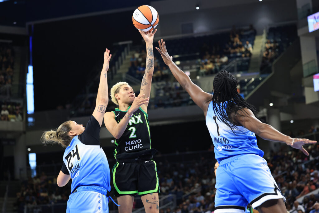 Minnesota Lynx guard Natisha Hiedeman shoots over two Chicago Sky defenders during a 2025 WNBA game.
