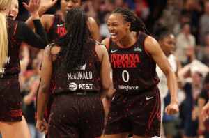 Indiana Fever guard Kelsey Mitchell celebrates teammate Aari McDonald's three-pointer during a 2025 WNBA game.
