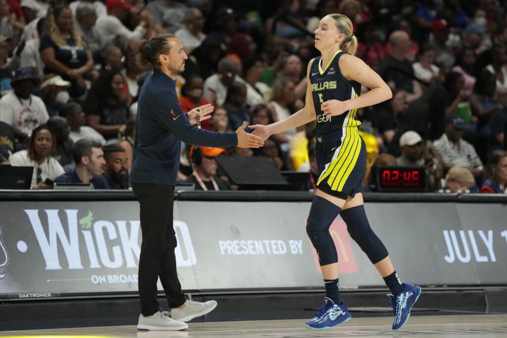 Dallas Wings rookie Paige Bueckers high-fives head coach Chris Koclanes during a 2025 WNBA game.
