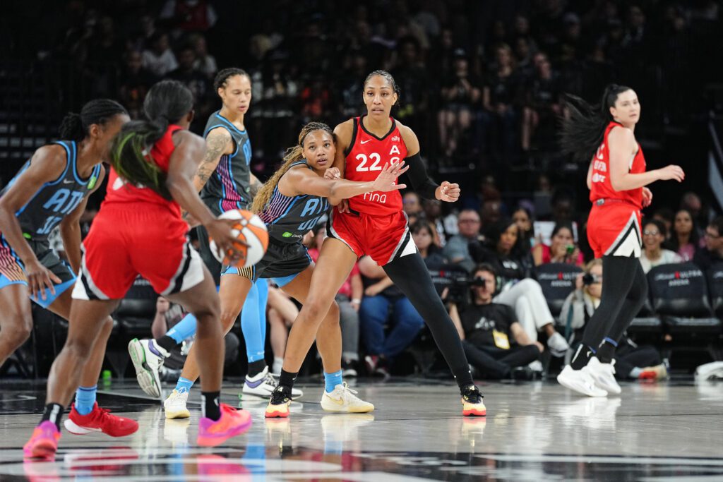 Atlanta Dream forward Naz Hillmon looks to intercept a pass to Las Vegas Aces center A'ja Wilson during a 2025 WNBA game.