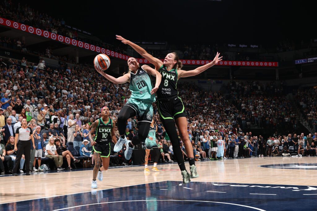 Minnesota Lynx forward Alanna Smith reaches to block a shot from New York Liberty guard Sabrina Ionescu during a 2025 WNBA game.