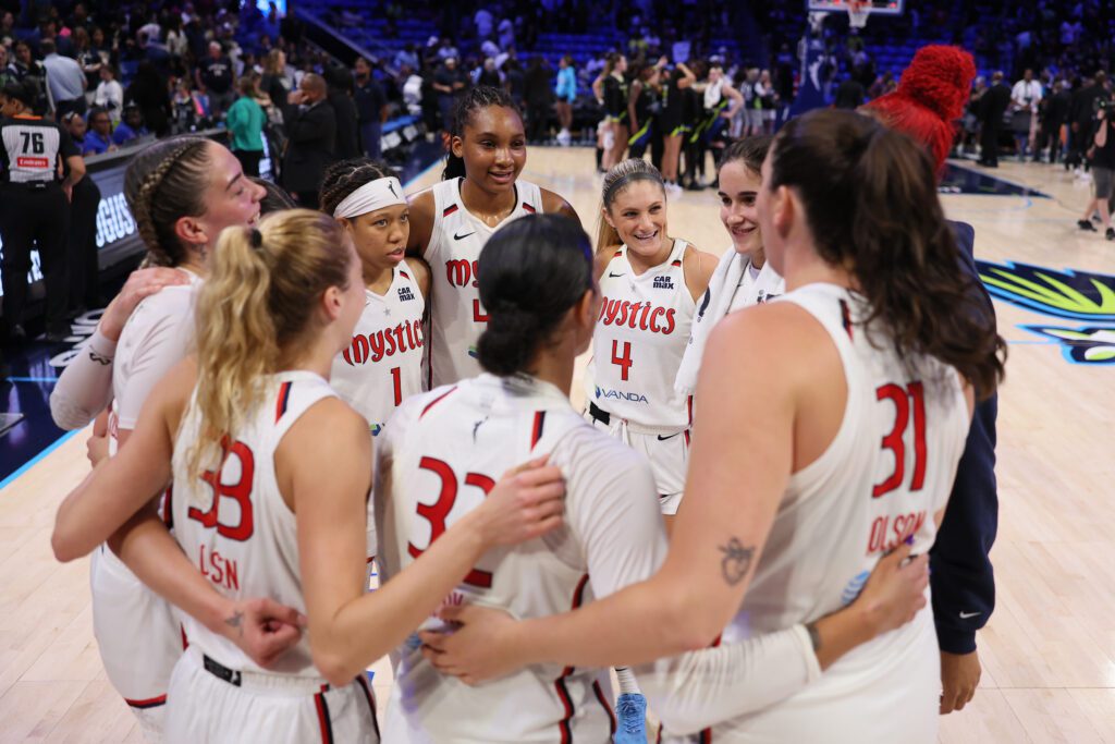 The Washington Mystics huddle and celebrate a 2025 WNBA win.