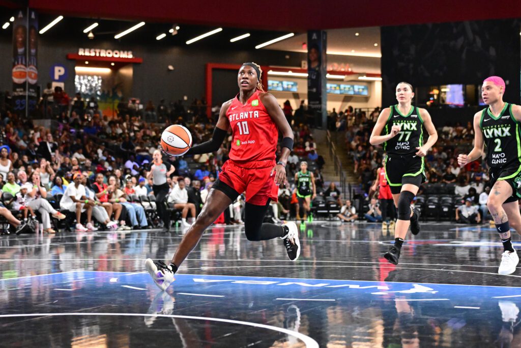 Atlanta Dream guard Rhyne Howard drives to the basket as Minnesota Lynx forward Maria Kliundikova and guard Natisha Hiedeman give chase during a 2025 WNBA game.