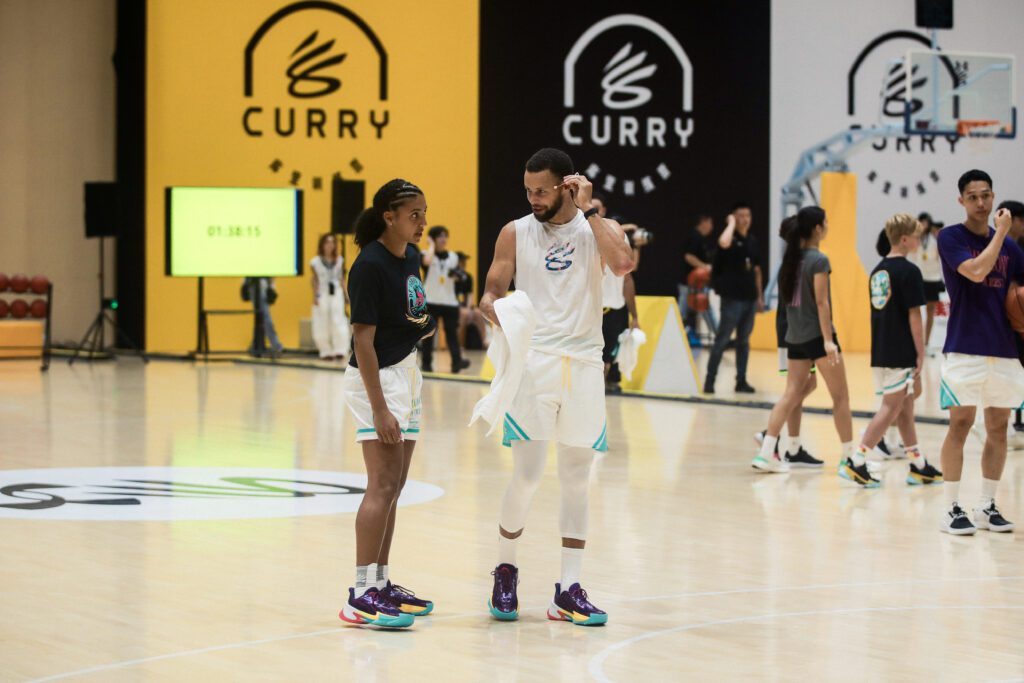 UConn standout Azzi Fudd and NBA star Steph Curry chat on the court during the China edition of Curry Camp in 2025.