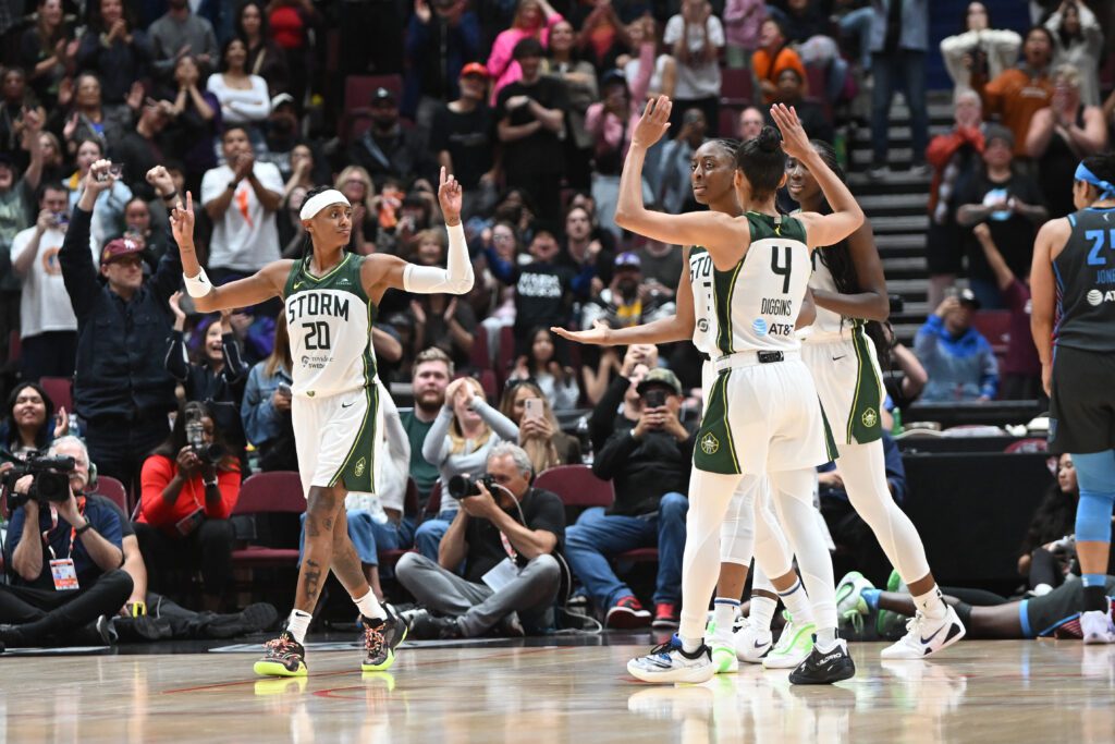 Seattle Storm guard Brittney Sykes celebrates a win with teammates Skylar Diggins and Nneka Ogwumike after a 2025 WNBA game.
