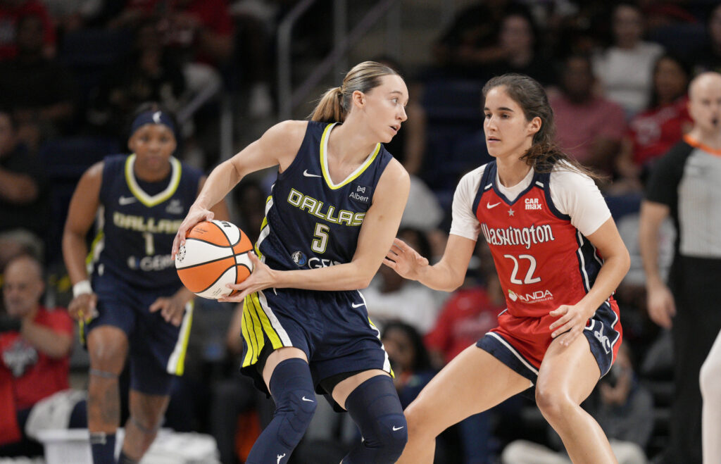 Dallas Wings guard Paige Bueckers controls the ball as Washington Mystics guard Sonia Citron defends during a 2025 WNBA game.