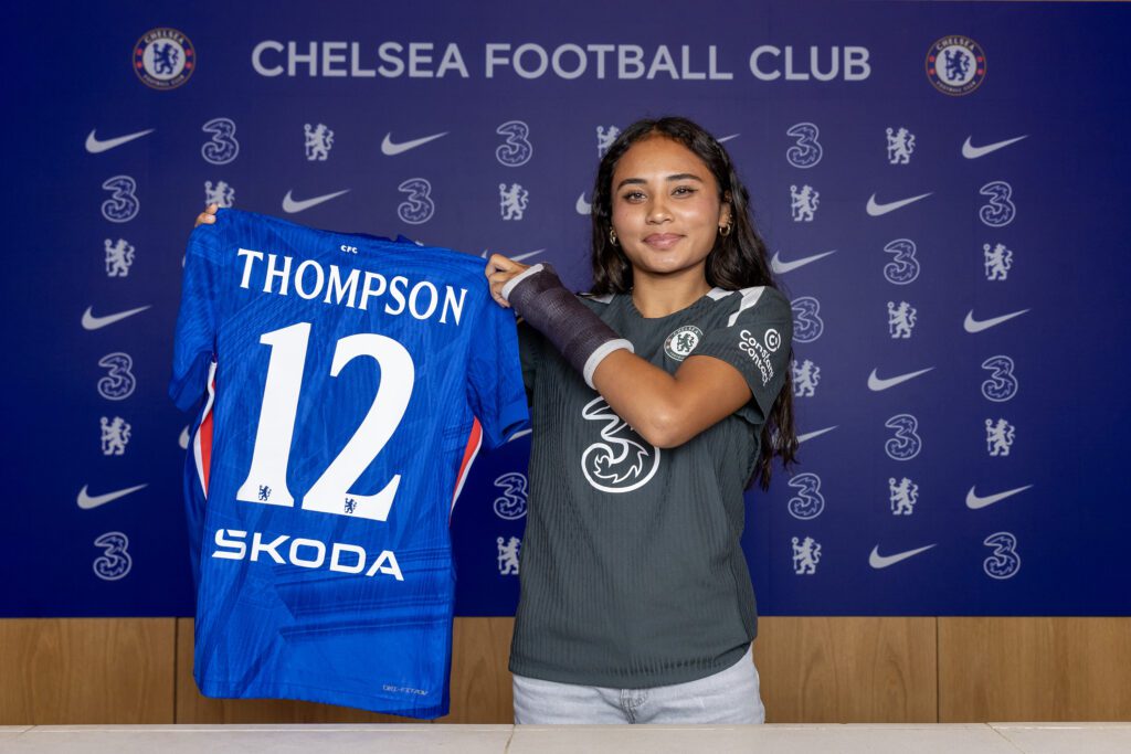 USWNT forward Alyssa Thompson poses holding a Chelsea FC jersey after her 2025 signing with the WSL club.