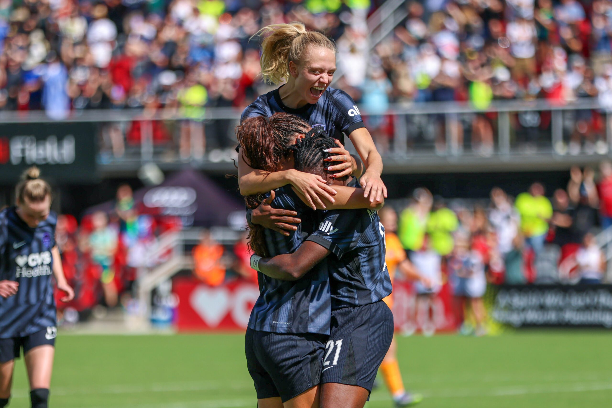Washington Spirit forward Trinity Rodman and defender Esme Morgan hug goal-scorer Gift Monday during a 2025 NWSL match.
