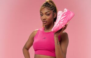 WNBA star Angel Reese poses holding her signature Reebok shoe in the colorway "Mebounds."