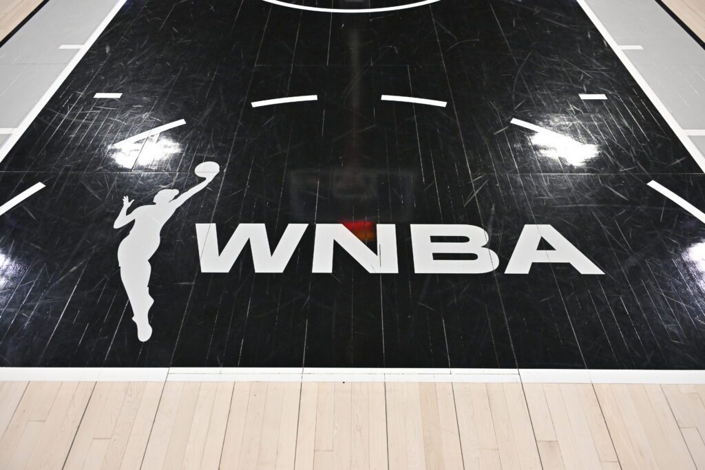 A close-up of the WNBA logo on the court before a 2025 game.