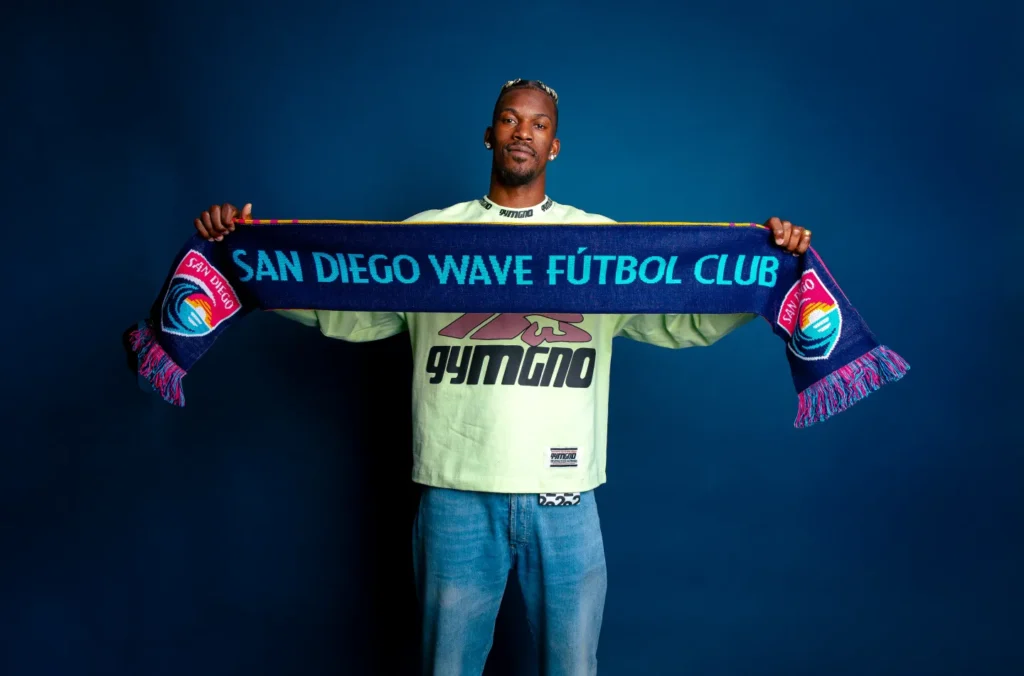 Golden State Warriors forward Jimmy Butler poses holding a San Diego Wave scarf.