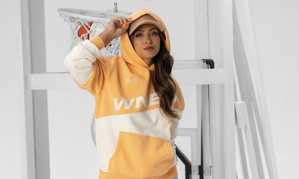 A model wears a WNBA hoodie from The Wild Collective's line at Target.