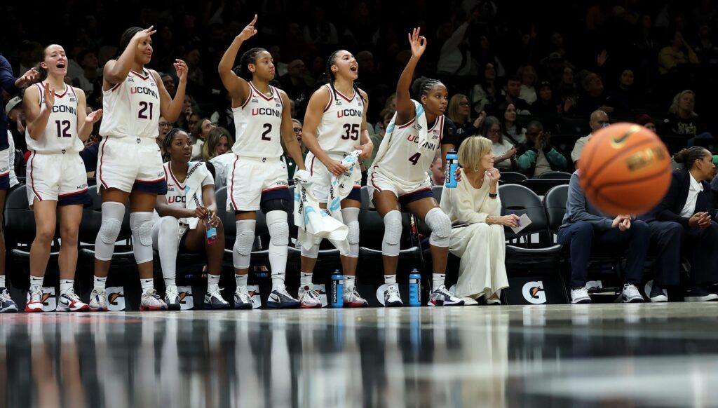 The UConn Huskies' bench celebrates a play during a 2025/26 NCAA basketball game.