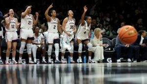The UConn Huskies' bench celebrates a play during a 2025/26 NCAA basketball game.