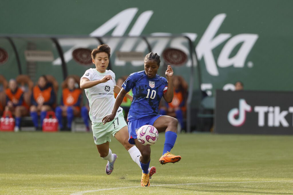 Racing Louisville midfielder Shuang Wang chases down USWNT U-23 right back Ayo Oke as Oke controls the ball during a 2023 exhibition match.