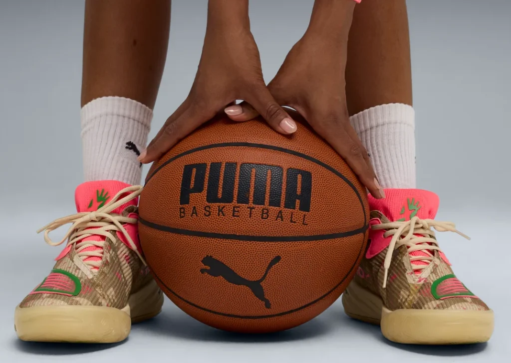 Hands hold a Puma basketball between feet wearing the new player-exclusive Puma All-Pro Nitro 2 colorway from LSU star Flau'jae Johnson.