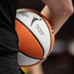 A referee holds an official WNBA basketball during a 2024 game.