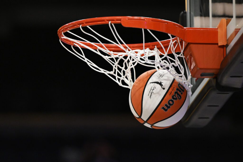 An official WNBA basketball clears the net after a successful shot prior to a 2025 season game.