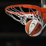 An official WNBA basketball clears the net after a successful shot prior to a 2025 season game.