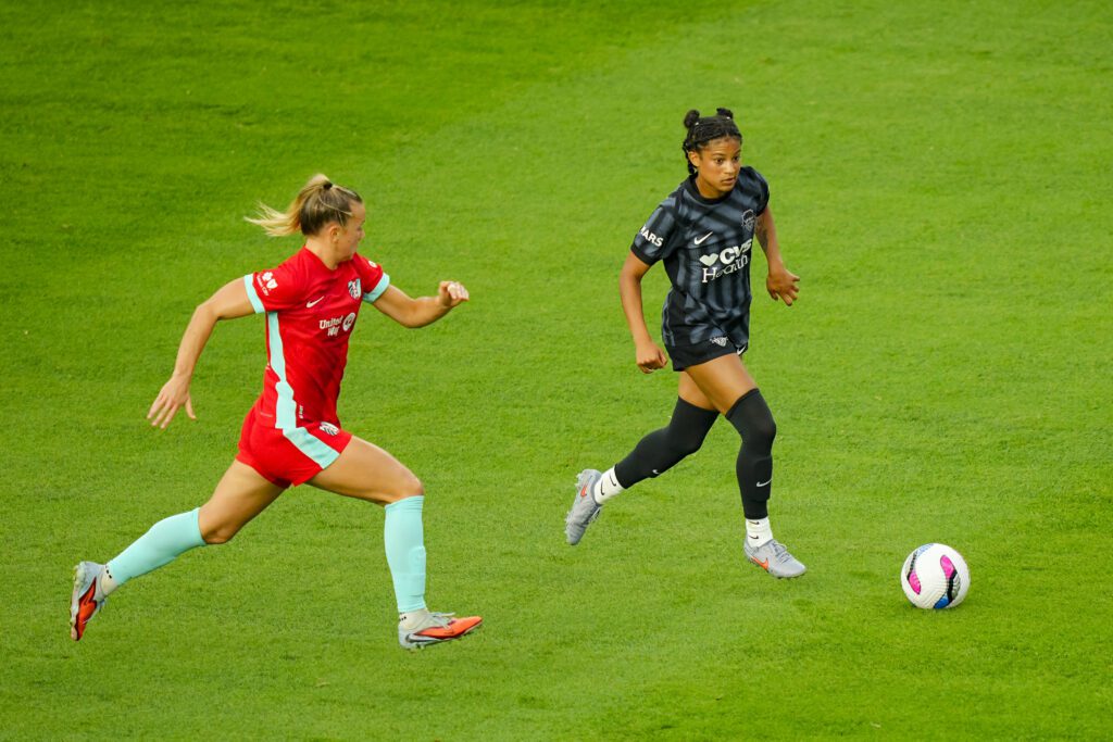 Kansas City Current midfielder Claire Hutton chases Washington Spirit star Croix Bethune, who controls the ball, during a 2025 NWSL match.