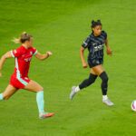 Kansas City Current midfielder Claire Hutton chases Washington Spirit star Croix Bethune, who controls the ball, during a 2025 NWSL match.
