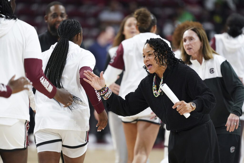 South Carolina head coach Dawn Staley high-fives her players before a 2024/25 NCAA basketball game.