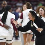 South Carolina head coach Dawn Staley high-fives her players before a 2024/25 NCAA basketball game.