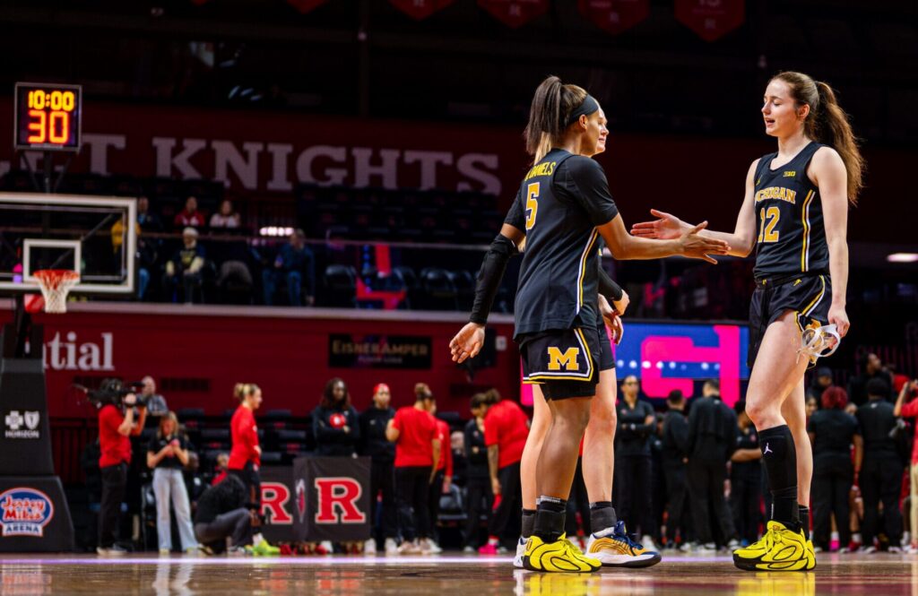 Michigan sophomore Syla Swords high-fives senior Brooke Quarles Daniels as she is introduced before a 2025/26 NCAA basketball game.