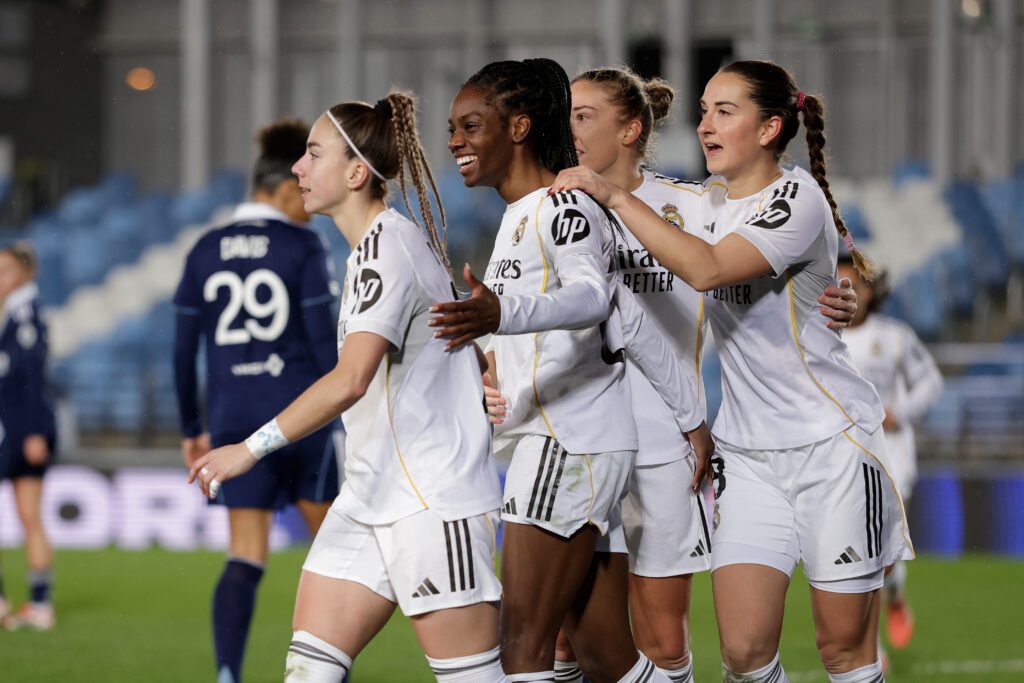 Real Madrid winger Athenea, forward Naomie Feller, and midfielder Sara Däbritz celebrate a goal during a 2025/26 UEFA Champions League Round of 16 match.