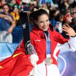 Chinese freeskiier Eileen Gu waves to the crowd during the medal ceremony after winning halfpipe gold on the last day of the 2026 Winter Olympics.