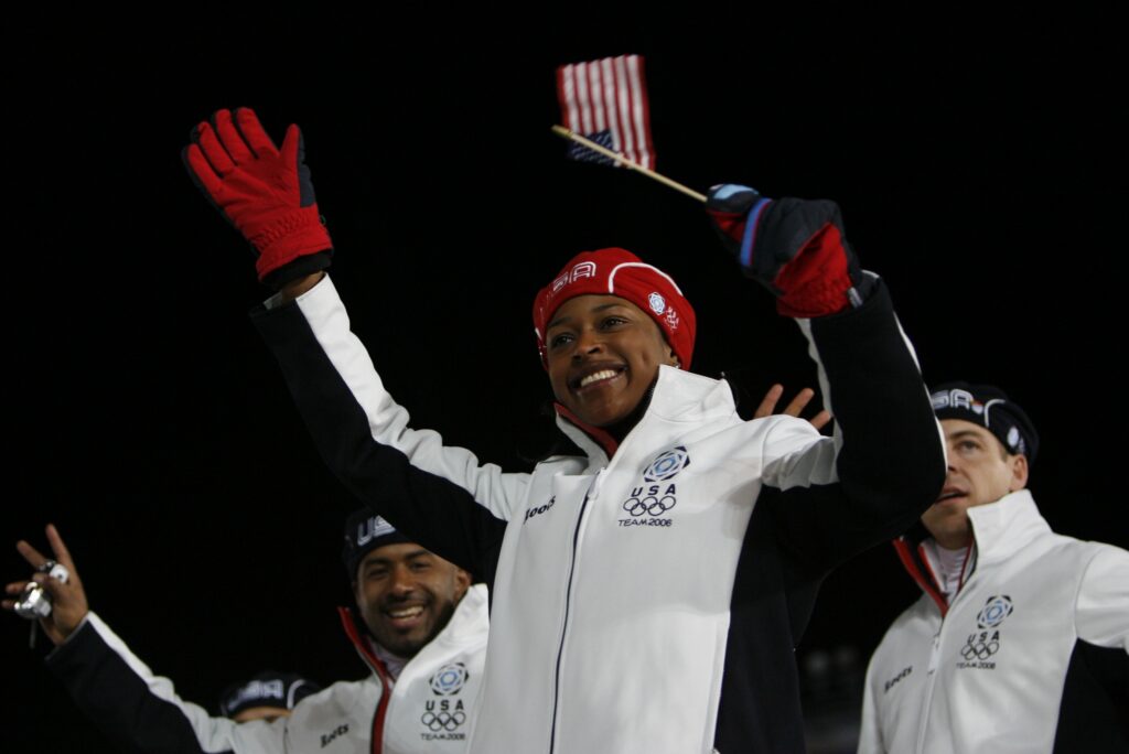 Team USA bobsledder Vonetta Flowers waves to the crowd at the 2006 Winter Olympics opening ceremony.