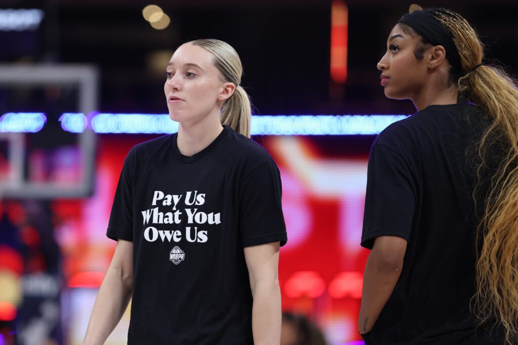 Paige Bueckers and Angel Reese wear T-shirts saying "Pay Us What You Owe Us" ahead of the 2025 WNBA All-Star Game.
