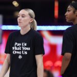 Paige Bueckers and Angel Reese wear T-shirts saying "Pay Us What You Owe Us" ahead of the 2025 WNBA All-Star Game.