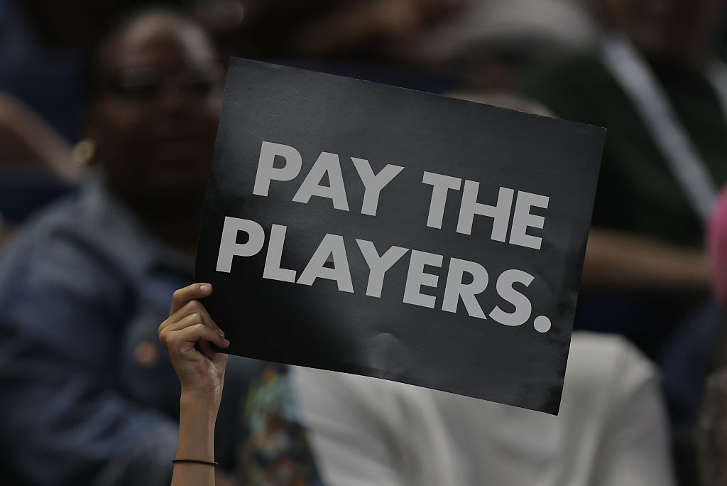 A fan holds a pay the players sign during a game against the Seattle Storm and the Chicago Sky on July 24, 2025 at Wintrust Arena in Chicago, Illinois.